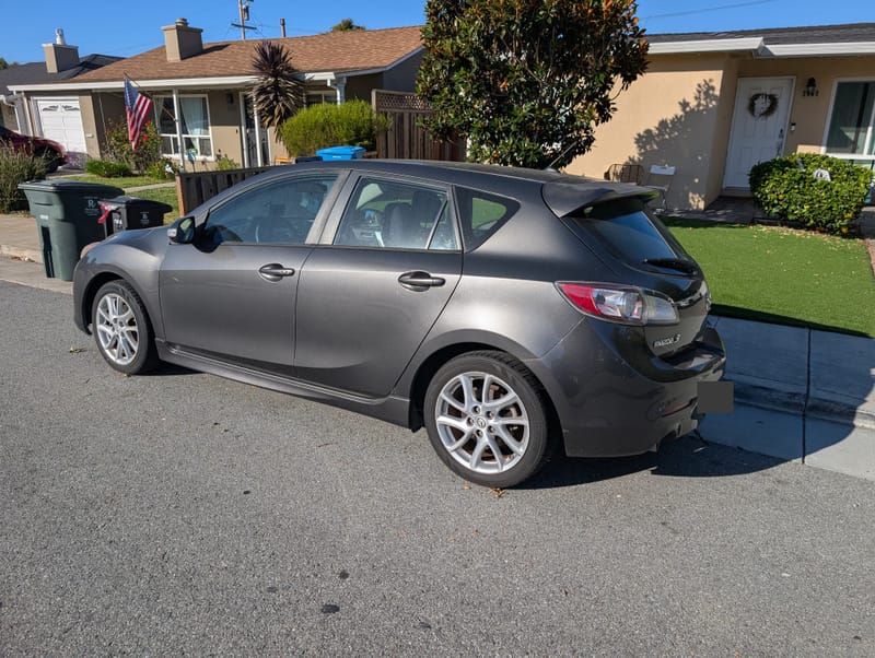 Rear three-quarter view of the Mazda3 showing the spoiler